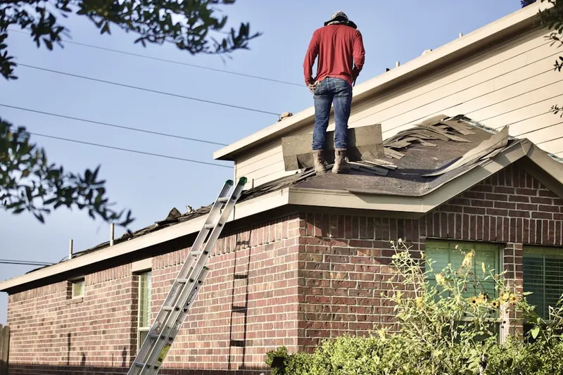 Professional roofer working on a residential roof in Cornish
